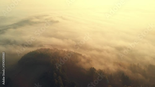 Flying Over Hills and Trees at Foggy Morning at Sunrise. Nature and Outdoor. Aerial Drone 4K Footage.
