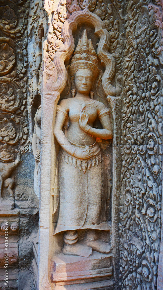 Fototapeta premium Stone rock carving art at Ta Prohm Temple in Angkor wat complex, Siem Reap Cambodia.