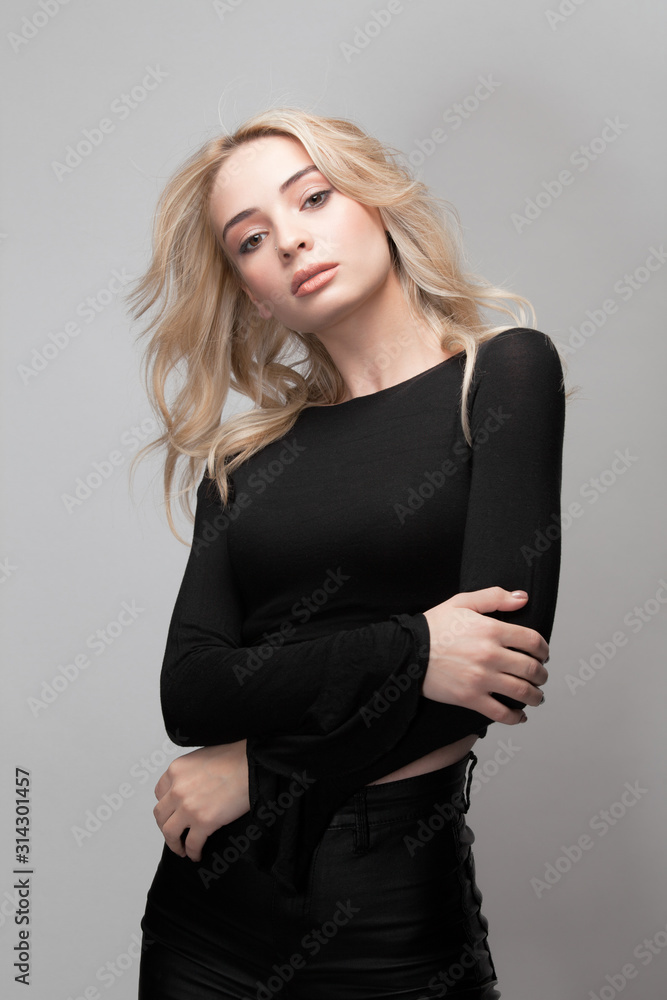 Woman portrait with make-up and long curly blonde hair and folded hands in black Woman portrait with make-up and long curly blonde hair and folded hands in black