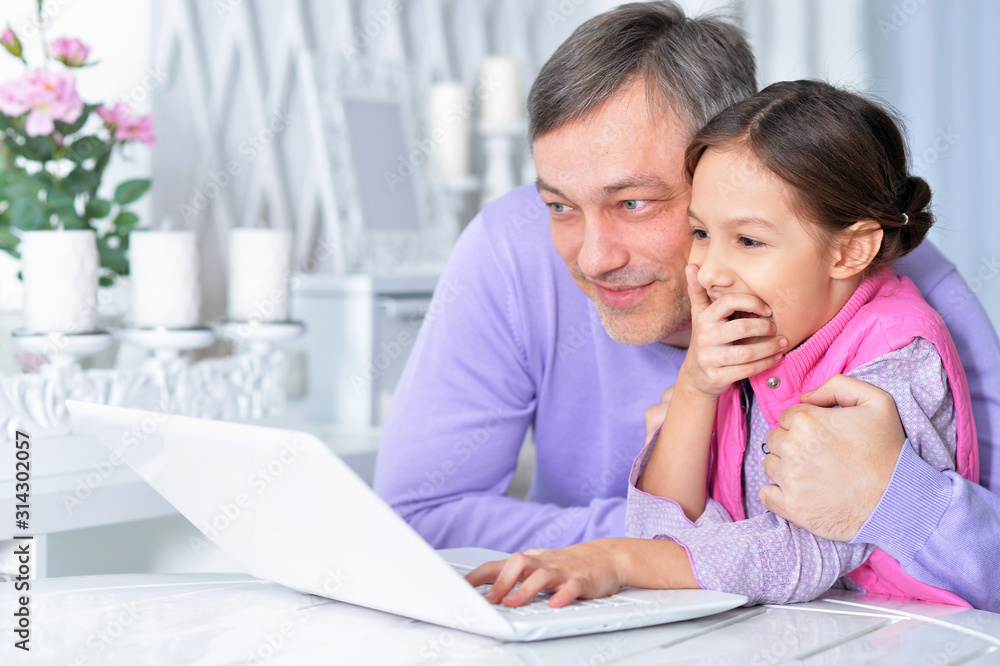 Portrait of father with little daughter using laptop Portrait of father with little daughter using laptop
