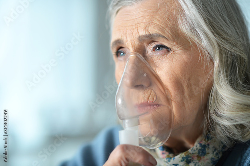 Close up portrait of senior woman with inhaler