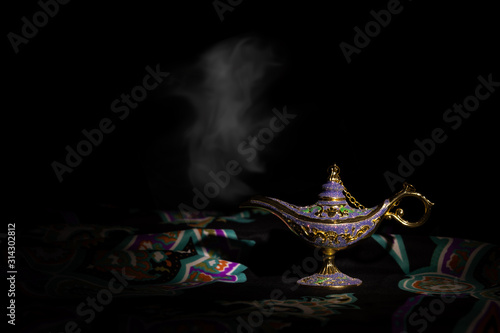 Aladdin magic lamp on a dark background with smoke