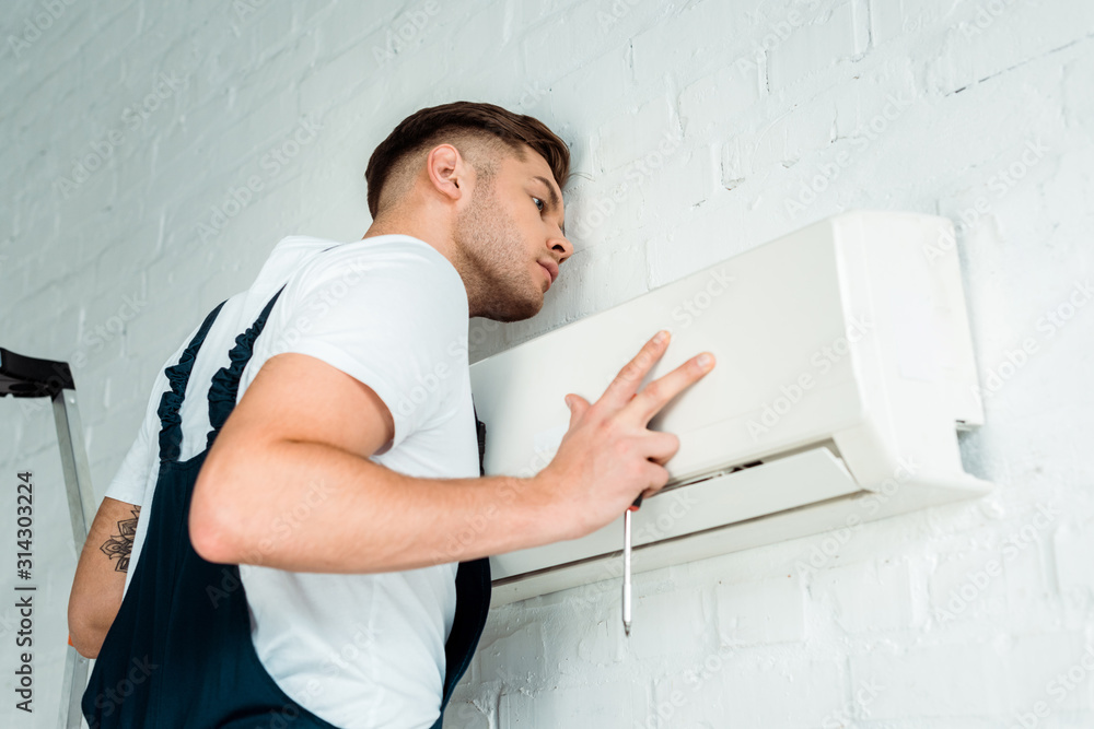 handsome worker installing air conditioner handsome worker installing air conditioner