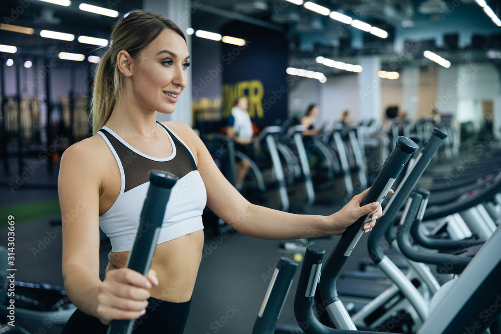 young beautiful girl doing exercises in the gym, jogging on the track indoors, fitness and crossfit young beautiful girl doing exercises in the gym, jogging on the track indoors, fitness and crossfit