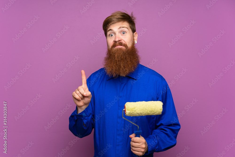 Painter man with long beard over isolated purple background pointing with the index finger a great idea Painter man with long beard over isolated purple background pointing with the index finger a great idea