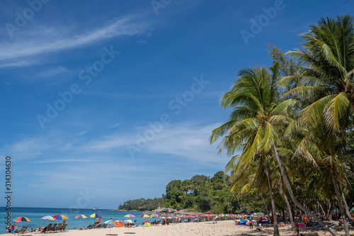 Fototapeta Naklejka Na Ścianę i Meble -  holiday on white sand beach with blue sky, colourful beach umbrella and coconut tree