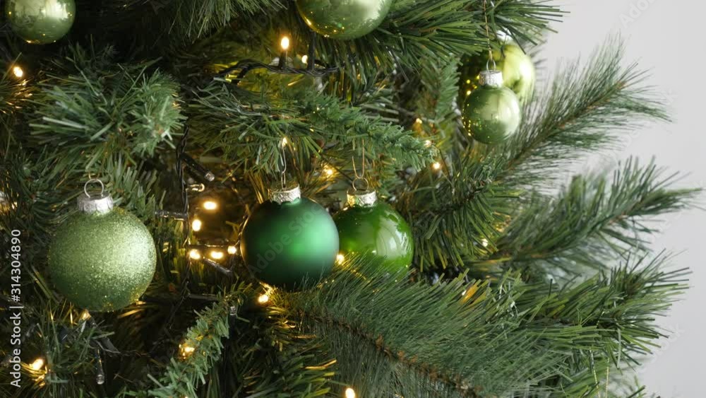Assorted green Christmas bulbs on artificial fir branches 4K video Assorted green Christmas bulbs on artificial fir branches 4K video