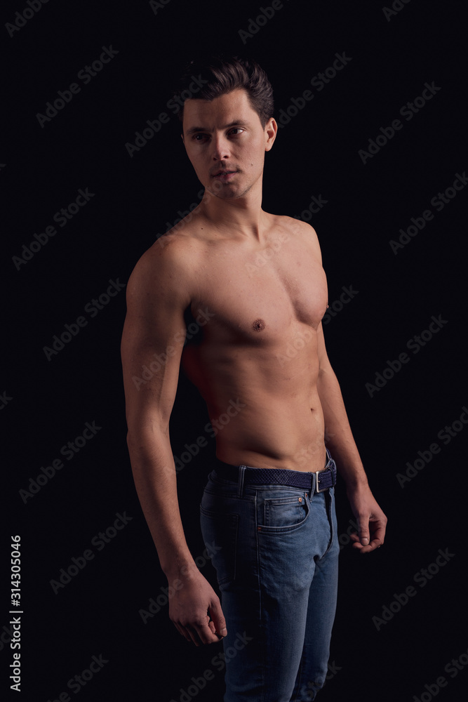 barechested guy with a dramatic light in the Studio. looking to the side pathetic