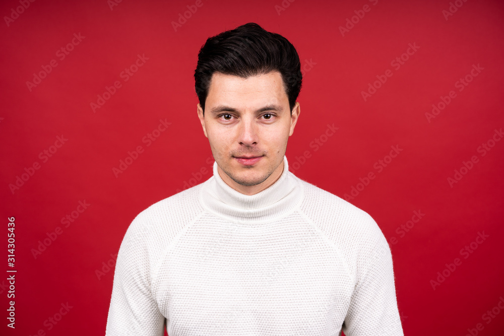 The guy looking at the camera. red background in the Studio, serious look The guy looking at the camera. red background in the Studio, serious look