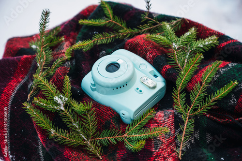 Instant camera on a blanket, pine and snow decoration by fonod photo