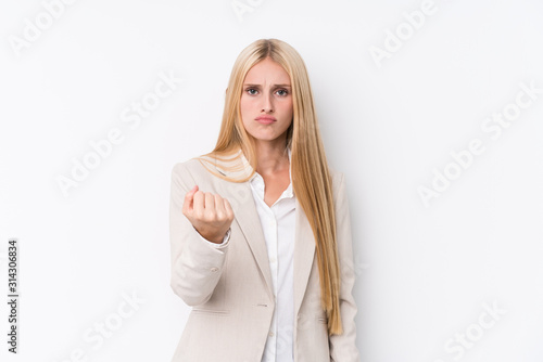 Young business blonde woman on white background showing fist to camera, aggressive facial expression.