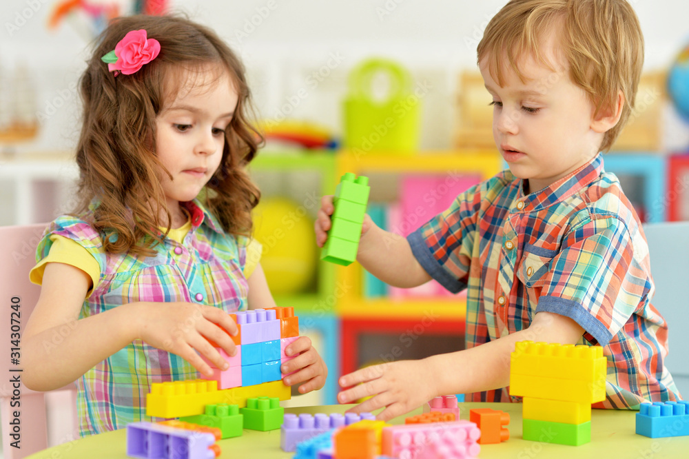 Naklejka premium Portrait of bother and sister playing with cubes