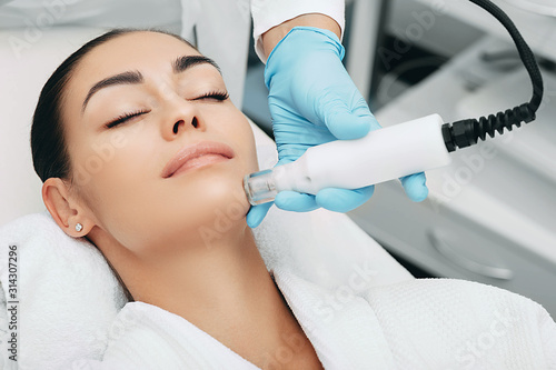 Photos woman receiving no-needle high frequency mesotherapy at beauty salon