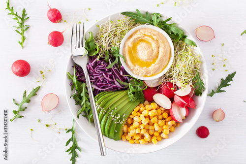 vegan avocado sweet corn lunch bowl with hummus, red cabbage, radish and sprouts photo