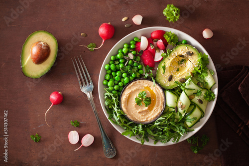 healthy vegan lunch bowl with avocaco cucumber hummus peas radish