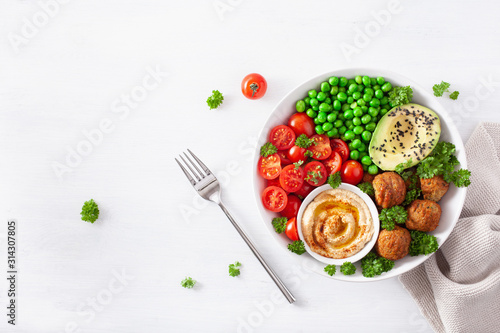 healthy vegan lunch bowl with falafel hummus tomato avocado peas