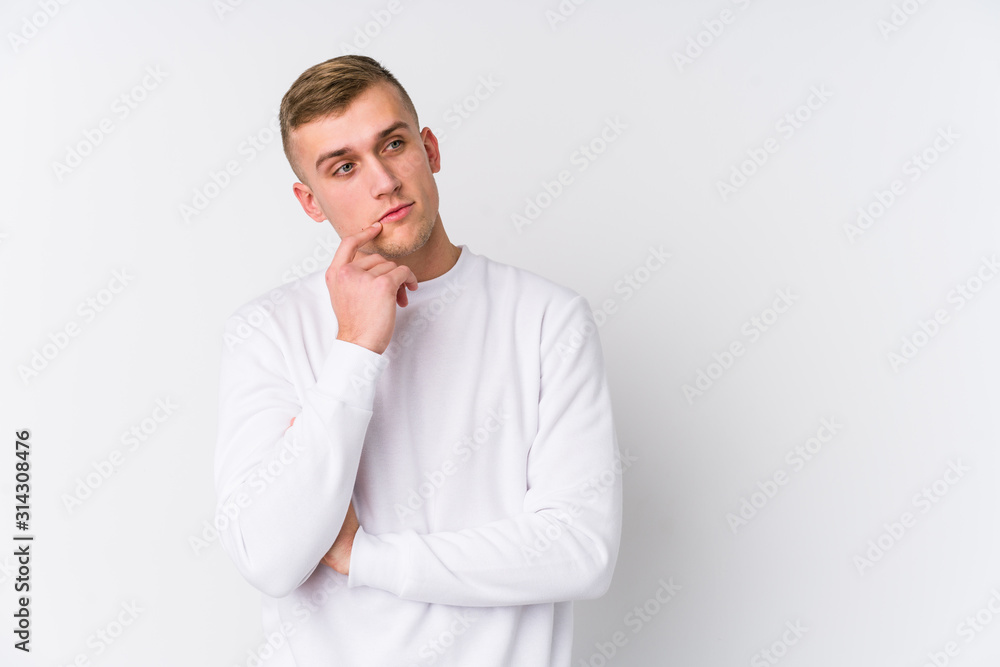 Young caucasian man on white background relaxed thinking about something looking at a copy space. Young caucasian man on white background relaxed thinking about something looking at a copy space.