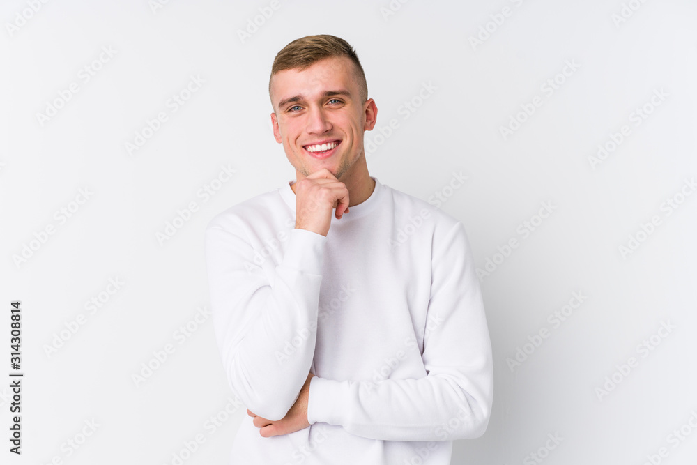 Young caucasian man on white background smiling happy and confident, touching chin with hand. Young caucasian man on white background smiling happy and confident, touching chin with hand.