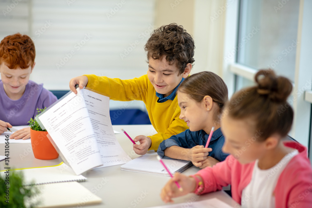 Generous boy sharing his test answers with the classmate Generous boy sharing his test answers with the classmate