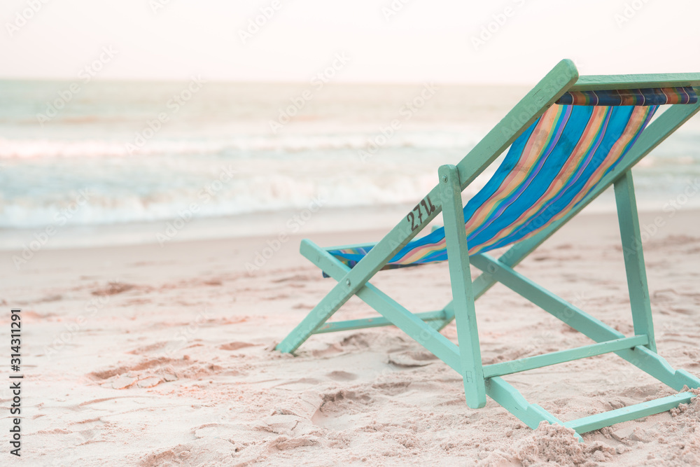 beach chair at side of beach with sunset background on autumn season beach chair at side of beach with sunset background on autumn season