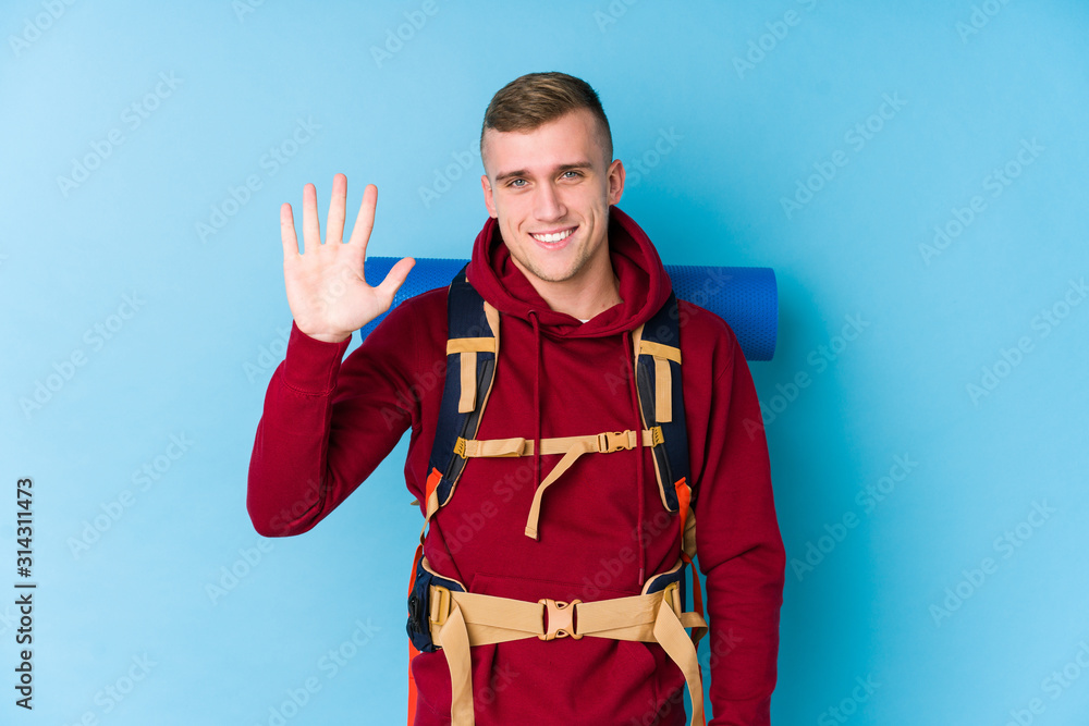 Young traveller caucasian man smiling cheerful showing number five with fingers. Young traveller caucasian man smiling cheerful showing number five with fingers.
