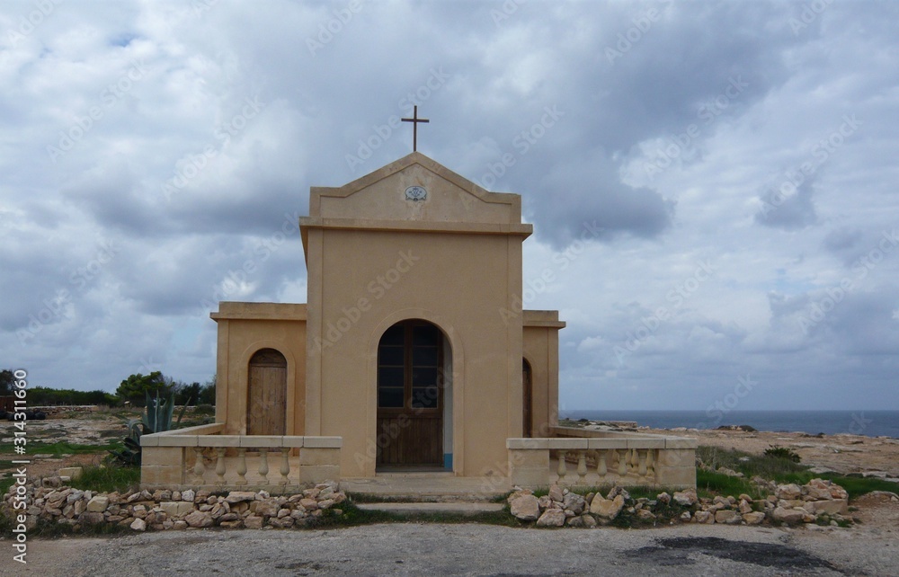 Chapel of Immaculate Conception - Chapel at Ahrax tal Mellieha with cross cleaving cloudy sky, overlooking, rugged, cliffed, coastline, Mellieha Sea, Malta 