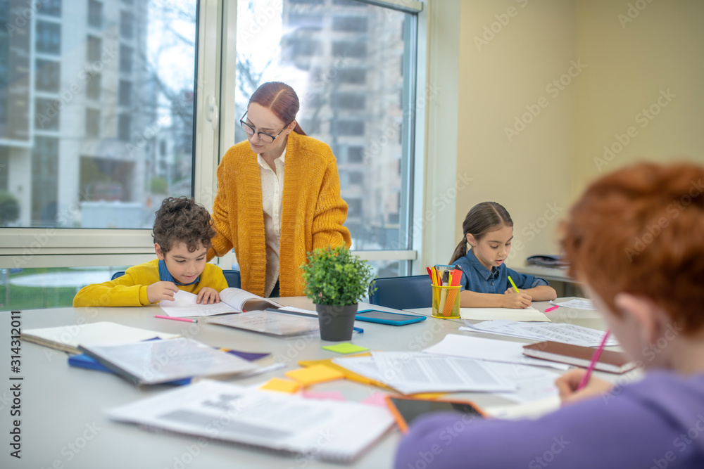 Teacher checking the work of her pupils Teacher checking the work of her pupils