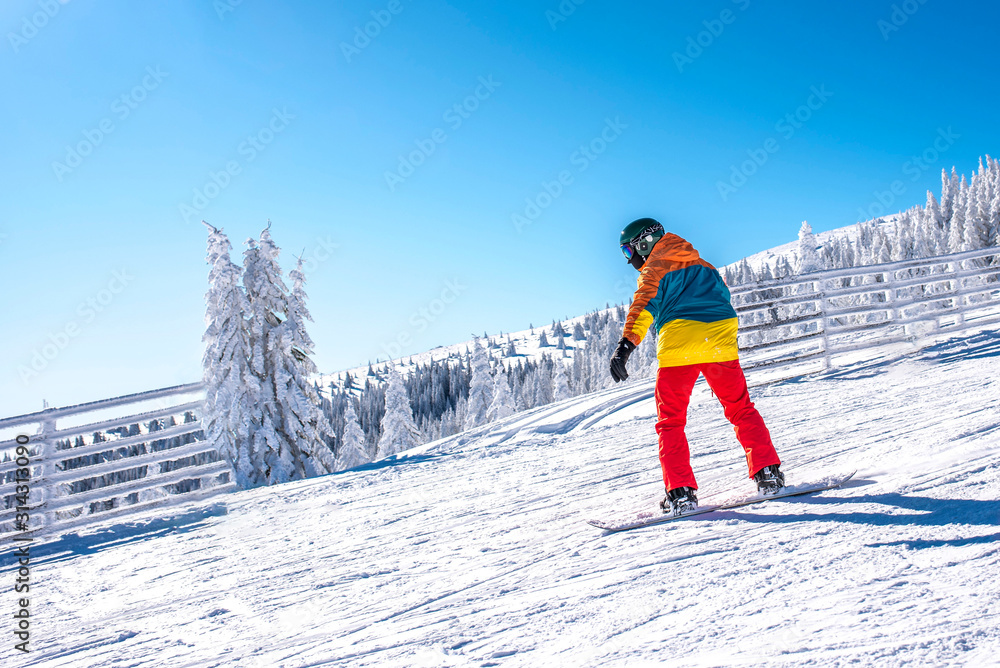 Active snowboarder enjoys snowboard ride in mountain ski resort