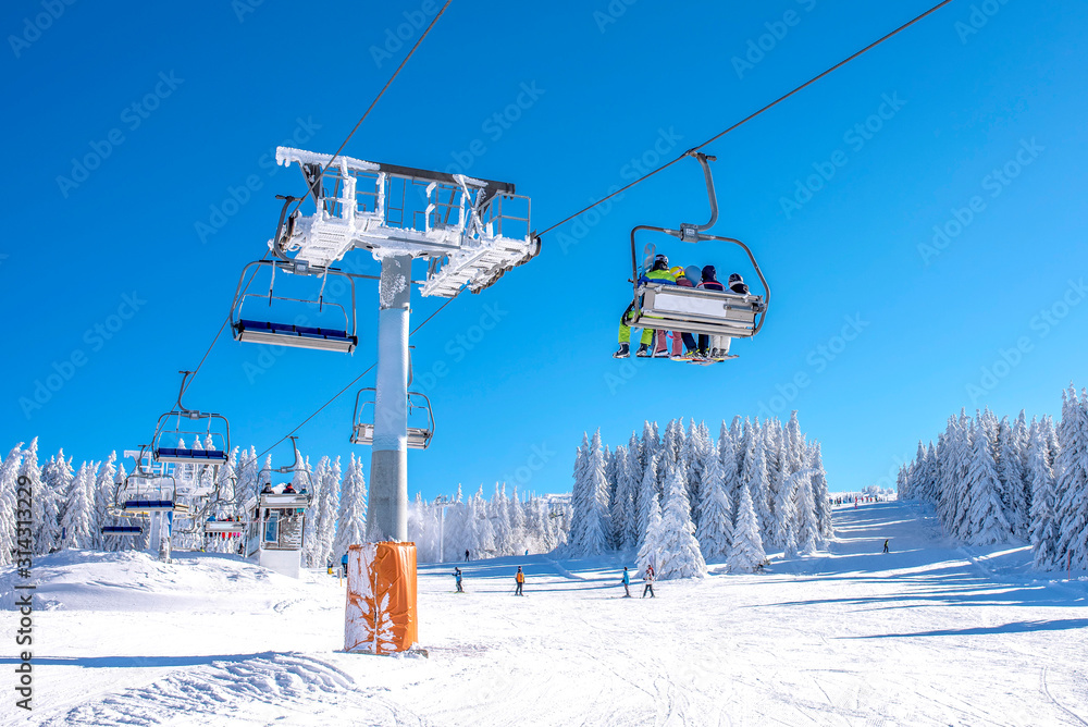 Winter sports concept. Skiers on chairlift at mountain ski resort Winter sports concept. Skiers on chairlift at mountain ski resort