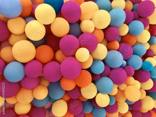 Many colorful festive balloons decorated wall as background