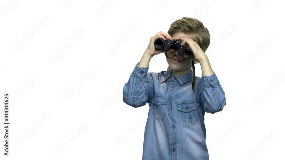Little caucasian boy looking through binoculars. Smiling child boy in denim jacket using binoculars. Isolated on white background. Little caucasian boy looking through binoculars. Smiling child boy in denim jacket using binoculars. Isolated on white background.