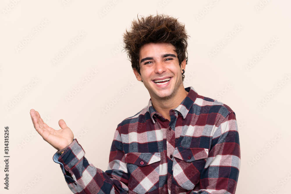 Young caucasian man extending hands to the side for inviting to come Young caucasian man extending hands to the side for inviting to come