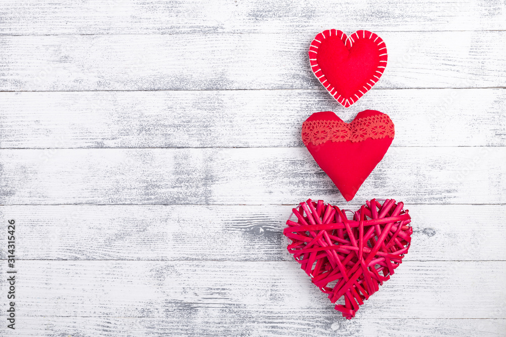 Fototapeta premium Red hearts on wooden white background. The concept of Valentine Day. Copy space for your text