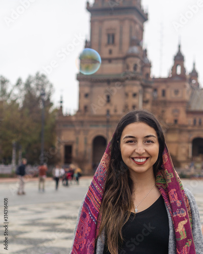 Woman smiling and standing in front of a historical building  © Tania