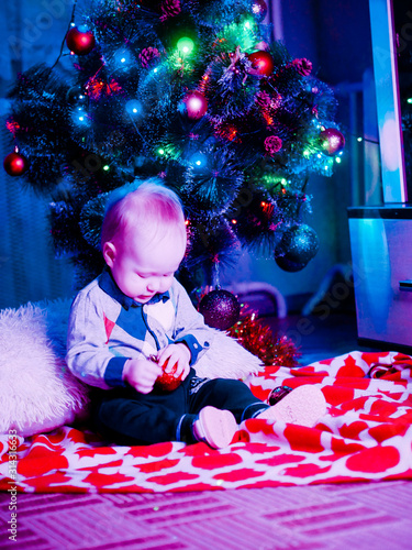 Baby with toys on the background of the Christmas tree