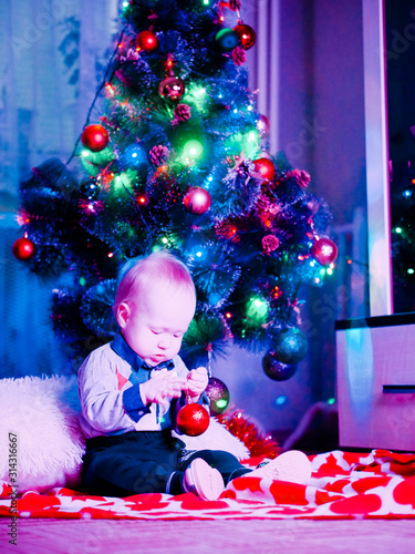 Baby with toys on the background of the Christmas tree