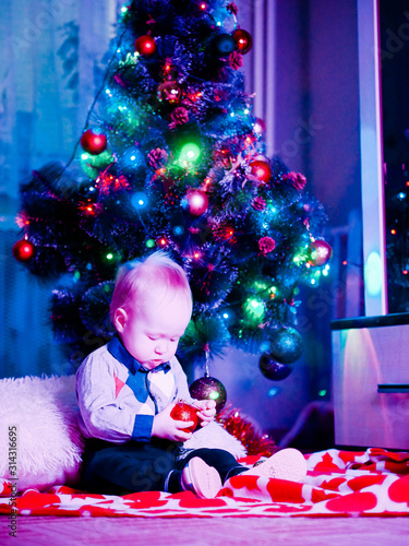 Baby with toys on the background of the Christmas tree