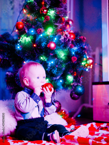 Baby with toys on the background of the Christmas tree