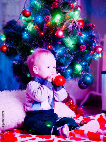 Baby with toys on the background of the Christmas tree