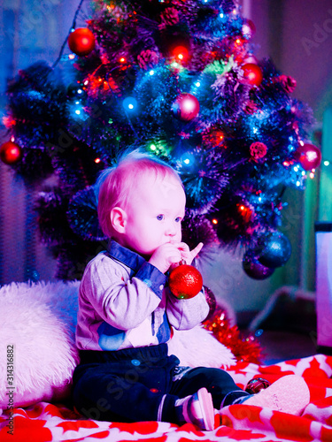 Baby with toys on the background of the Christmas tree
