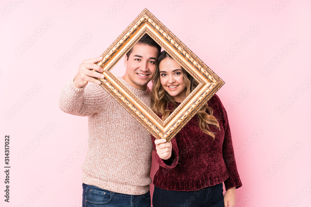 Fototapeta premium Young latin couple holding a frame
