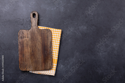 Photographie Cutting board and linen napkin on dark stone table. Copy space