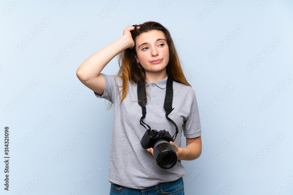 Young brunette girl over isolated blue background with a professional camera and thinking Young brunette girl over isolated blue background with a professional camera and thinking