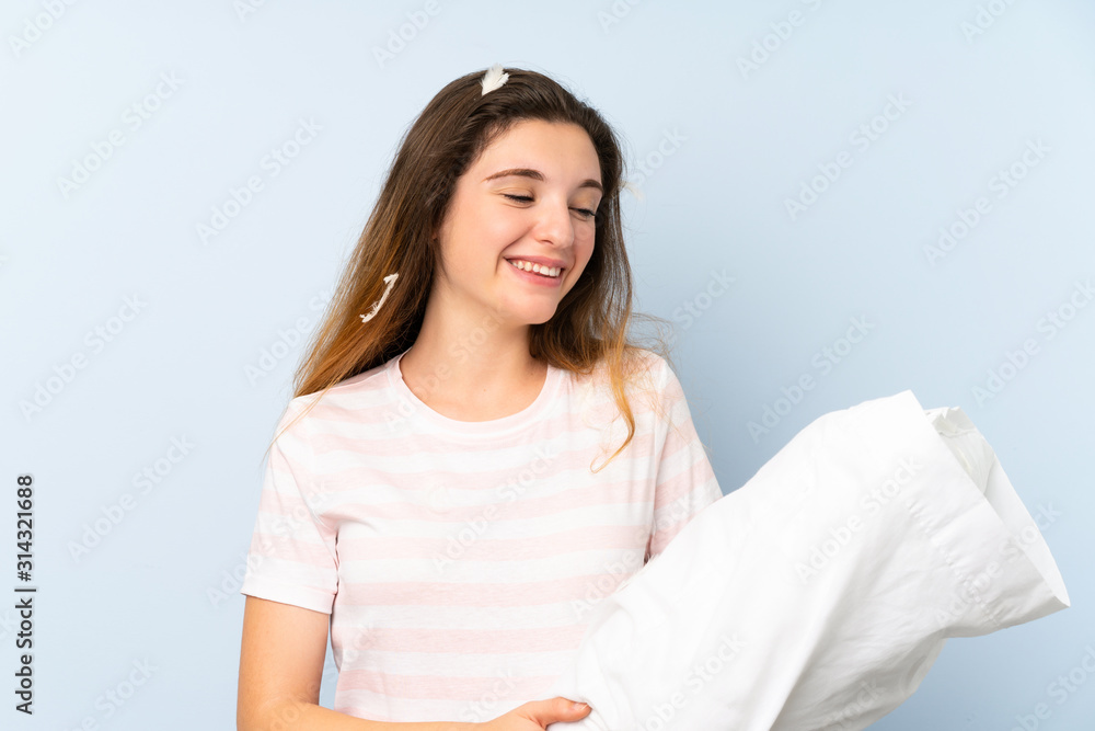 Young woman in pajamas over isolated blue background with happy expression Young woman in pajamas over isolated blue background with happy expression