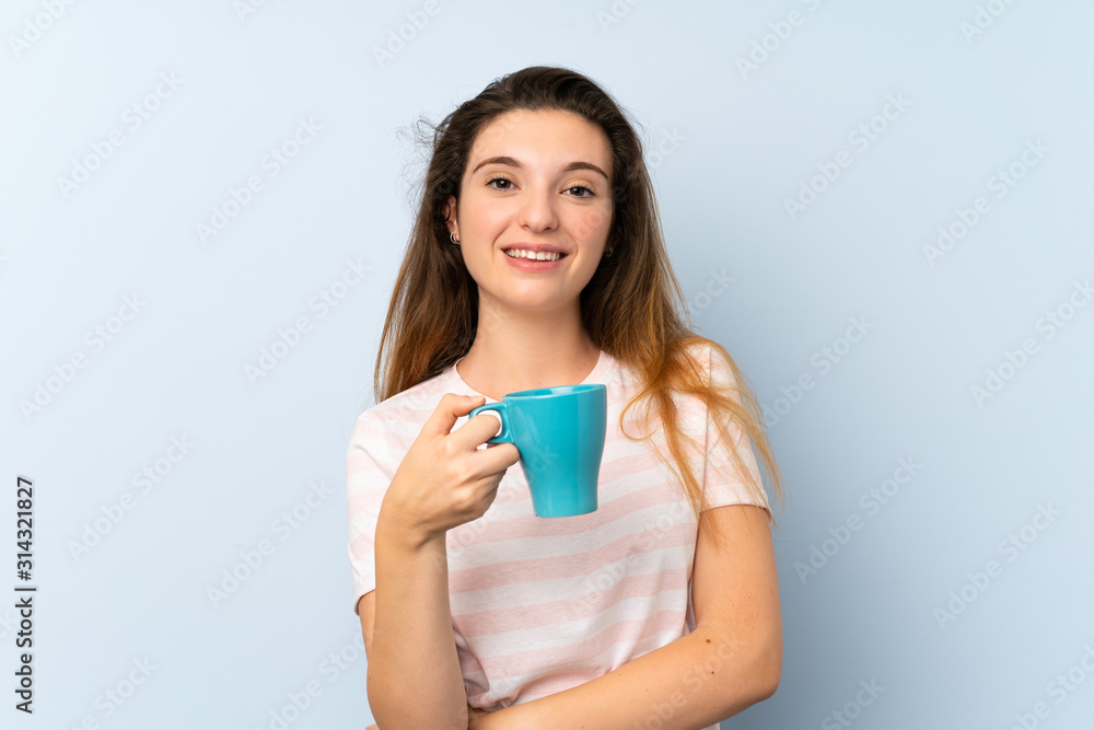 Young brunette girl holding a cup of coffee over isolated background Young brunette girl holding a cup of coffee over isolated background