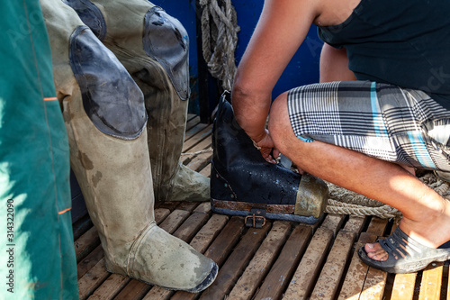 diver puts on diving galoshes on board a boat, close-up