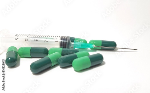 Green capsules and a syringe isolated