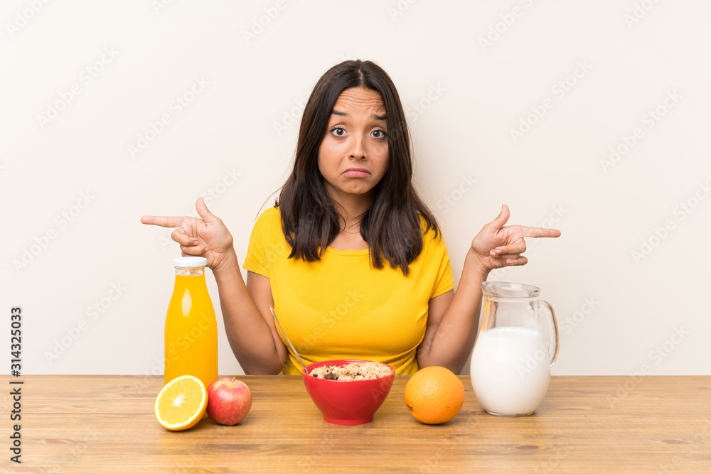 Young brunette girl having breakfast milk pointing to the laterals having doubts Young brunette girl having breakfast milk pointing to the laterals having doubts