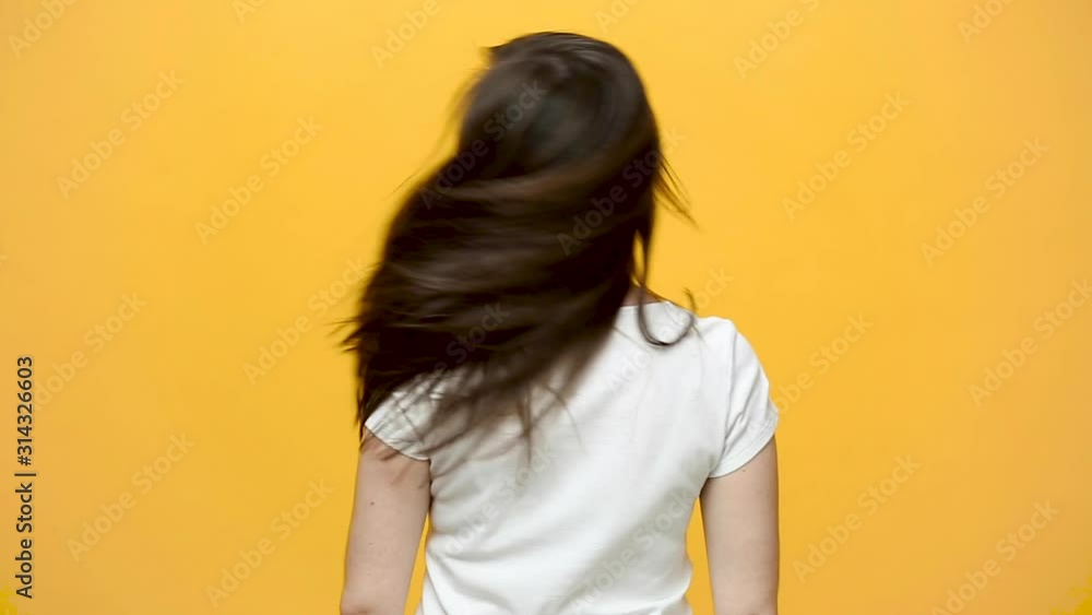 Back rear view brunette young woman in white t-shirt looking camera ...