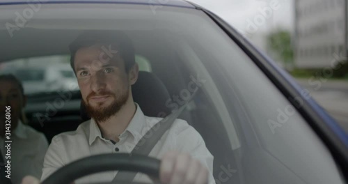 Man drives a car with a female passenger and picking her to work view through front window